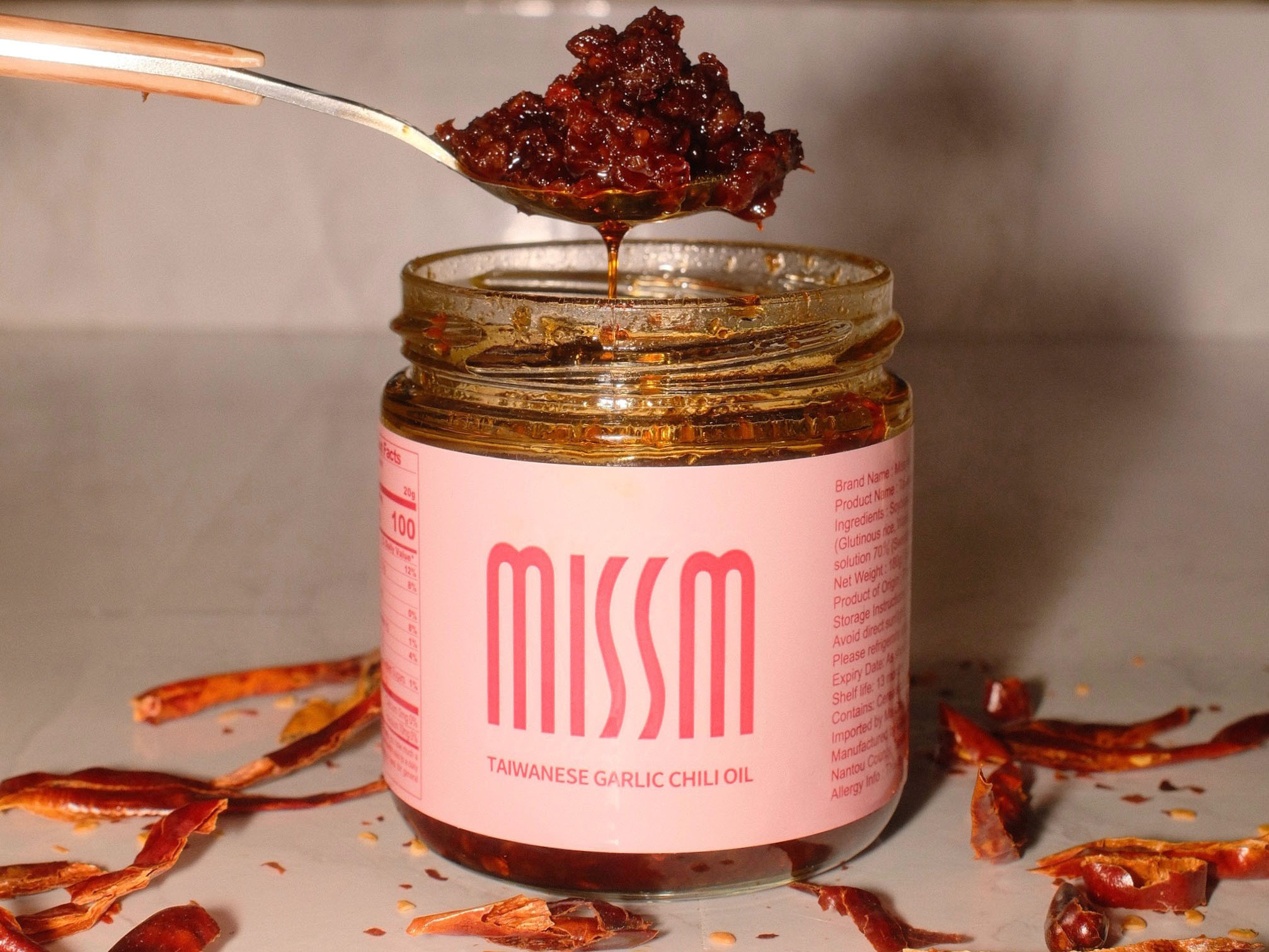Miss M Taiwanese garlic chili oil jar open with spoon drizzling oil